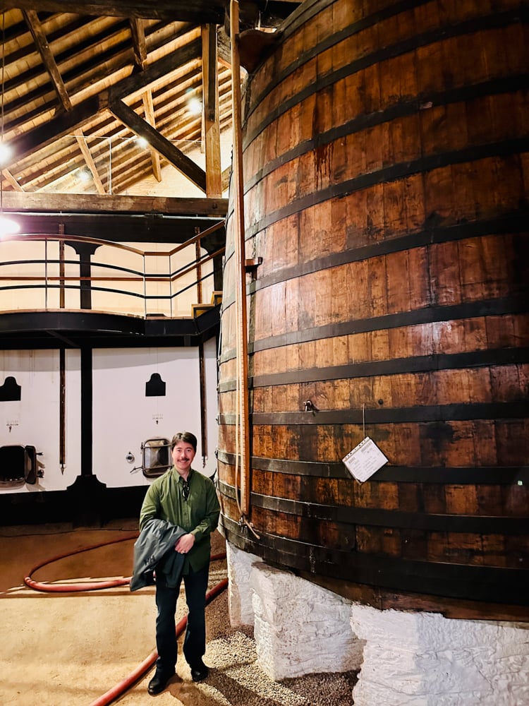 Pete standing next to wine barrel in Portugal.