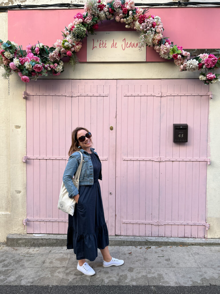 Rachelle standing by a pink door in the Rhone city of Arle