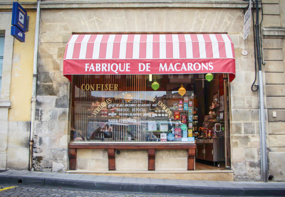 Storefront with red and white awning for Fabrique de macarons