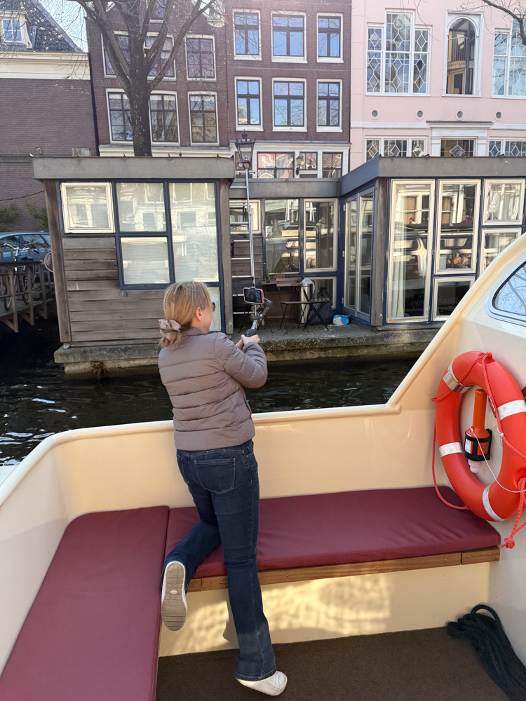 Rachelle taking pictures on the back of a boat in a canal in Amsterdam