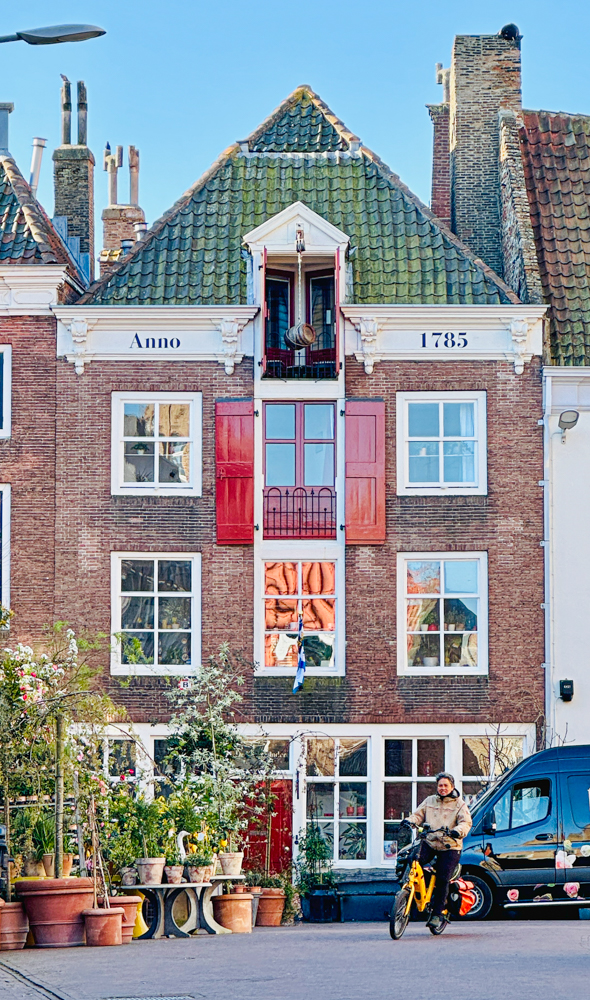 Dutch architecture and a cyclist pedaling by in Middleburg. The year on the building says Anno 1785