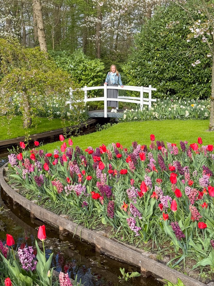 Rachelle standing on a white bridge with flower in the foreground