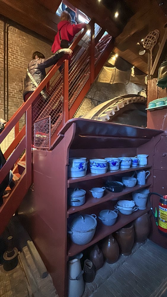 Stairs going over a shelf with shelf with pottery